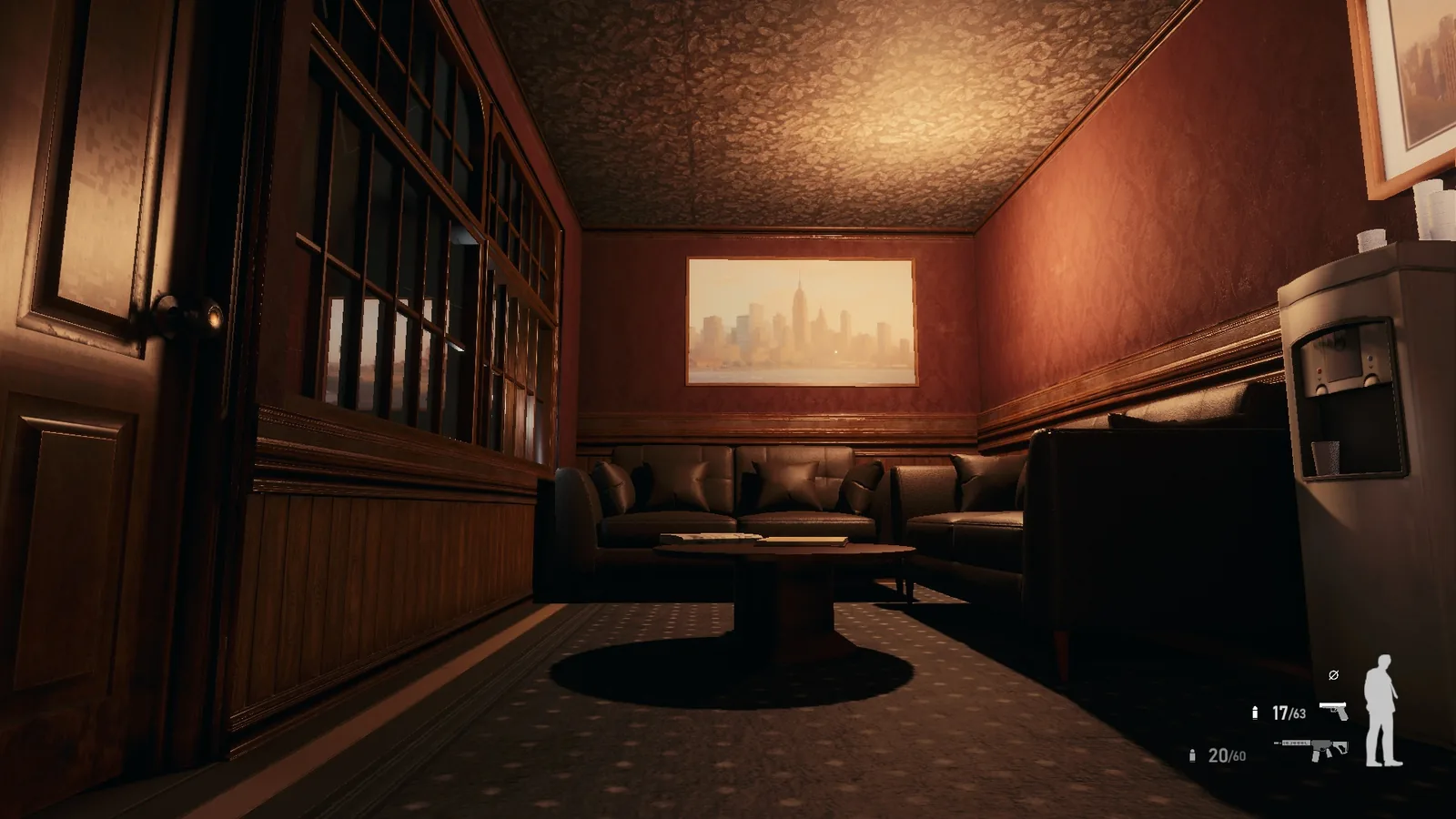 Wood-panelled lounge in BLACKWOOD with a leather sofa, round table, water cooler and a skyline painting
