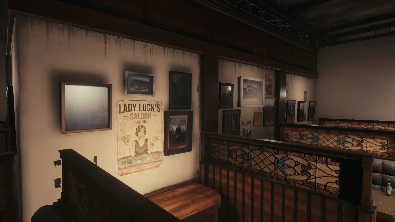 Corner of the BLACKWOOD bar set, with a vintage poster, framed photos, booths and a carved wooden screen