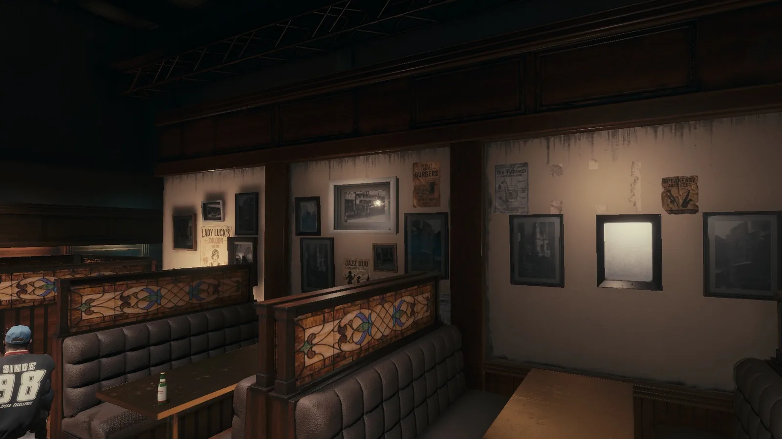 Leather booths and wooden tables in the BLACKWOOD bar set, with framed pictures on the walls