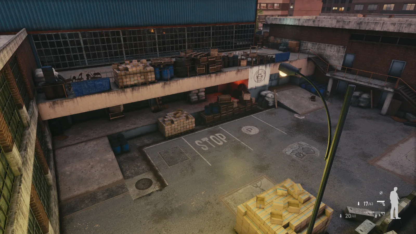 High view over the BLACKWOOD service yard, with painted STOP markings, a manhole, pallets and a covered loading dock