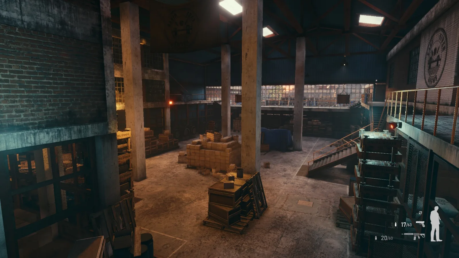 Inside the BLACKWOOD warehouse, with concrete columns, a steel staircase to the mezzanine, crates and caged lamps