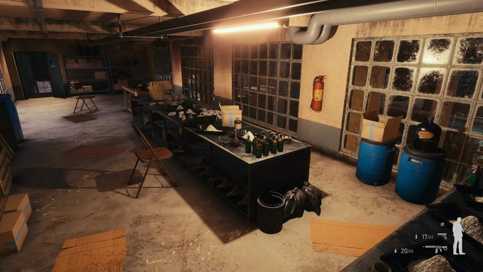Wide view of a BLACKWOOD workroom, with blue barrels, benches of bottles, overhead pipes and fluorescent tubes